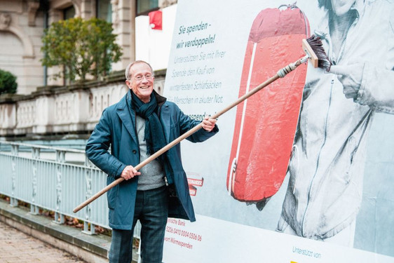 Axel Wintermeyer, Chef der Staatskanzlei, vor einem Plakat der Aktion #wärmespenden