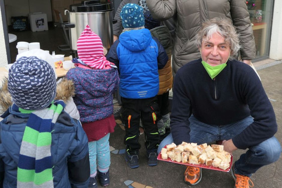 Axel Mitsch mit Kuchen und Kindern der Kita Wörthersee-Straße mit Quartiersmanagerin Angelika Wust