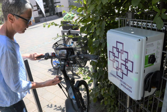 Am Zaun der KiTa Marktkirchengemeinde in Wiesbaden befindet sich jetzt eine E-Ladestation zur kostenfreien öffentlichen Nutzung.