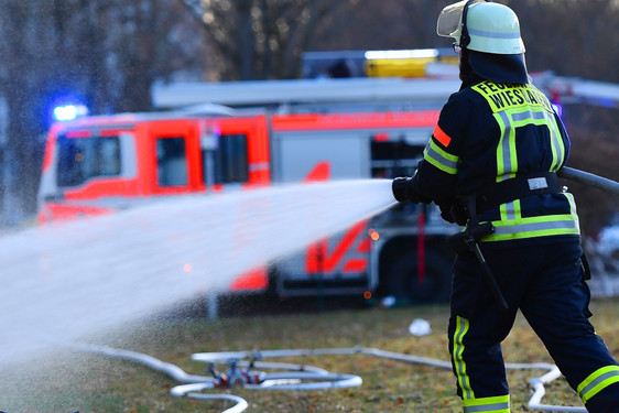 Brand zweier Gartenhütten in Wiesbaden-Dotzheim. Die Feuerwehr löscht die Flammen.