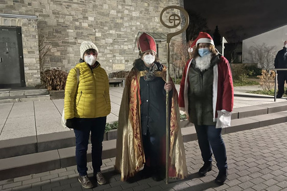 Lustige Begegnung am Nikolaustag: Ein Kind, der Bischof von Myra und der Weihnachtsmann kamen vor der Kirche Christ König in Wiesbaden-Nordenstadt ins Gespräch