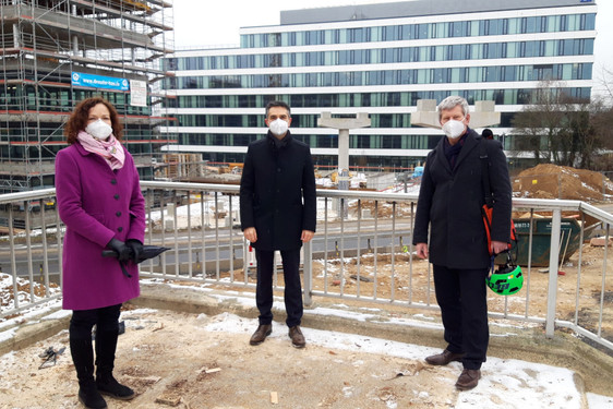 Patrizia Förster und Johannes Eichelberger von der R+V Versicherung machen sich gemeinsam mit Verkehrsdezernent Andreas Kowol vor Ort ein Bild vom Fortschritt der Bauarbeiten.